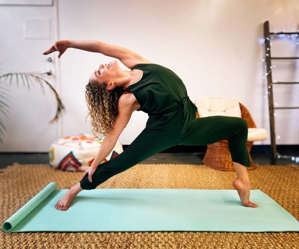 a-woman-that-is-happily-on-a-yoga-mat-in-a-flexibl-B4LDLZF.jpg